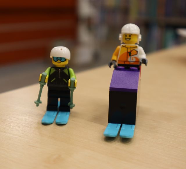 Na zdjęciu znajdują się ludziki na nartach z LEGO stojące na stoliku.