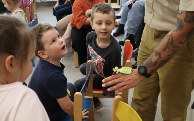dłoń z liśćcem, oglądające owada dzieci