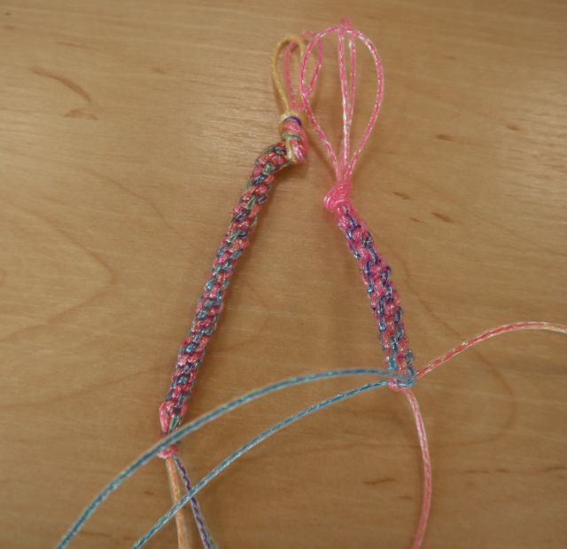 Na zdjęciu znajdują się dwa kolorowe breloczki leżące na stole. 