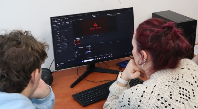 Na zdjęciu znajduje się kobieta oraz chłopak przy komputerze i montują film.