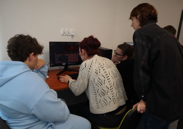 Na zdjęciu znajdują się dwie kobiety, dziewczyna oraz chłopak przy komputerze i montują animację poklatkową.