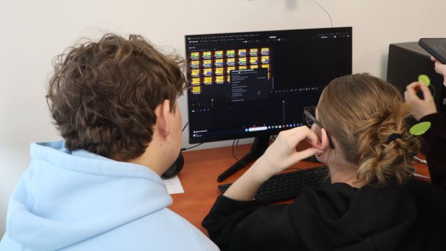 Na zdjęciu znajduje się dziewczyna oraz chłopak przy komputerze i wspólnie uczą się montować animację poklatkową.