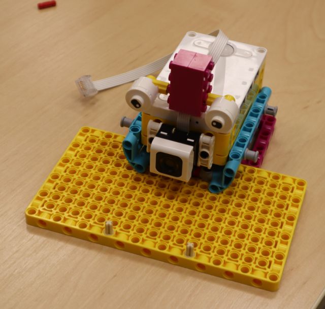 Na zdjęciu znajduje się robot z klocków LEGO Education, które stoi na stole.