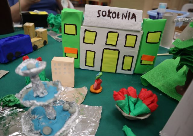 Na zdjęciu znajduje się część makiety miasta z kinem SOKOLNIA, roślinnością oraz fontanną.