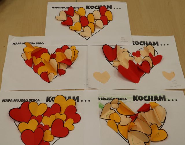 Na zdjęciu znajduje się pięć kartek z serduszkami, do których poprzyklejane są serduszka 3d. Prace znajdują się na stole.