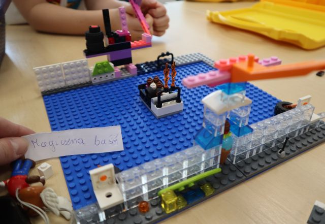 Na zdjęciu znajdują się klocki LEGO przedstawiające magiczną baśń. Konstrukcja znajduje się na stole.