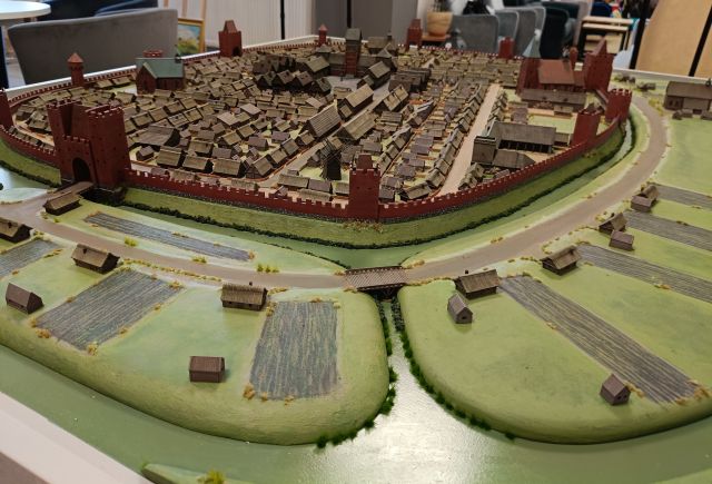 Na zdjęciu znajduje sie fragment makiety przedstawiającej szesnastowieczną Słupcę, a dokładnie fosę oraz budynki.