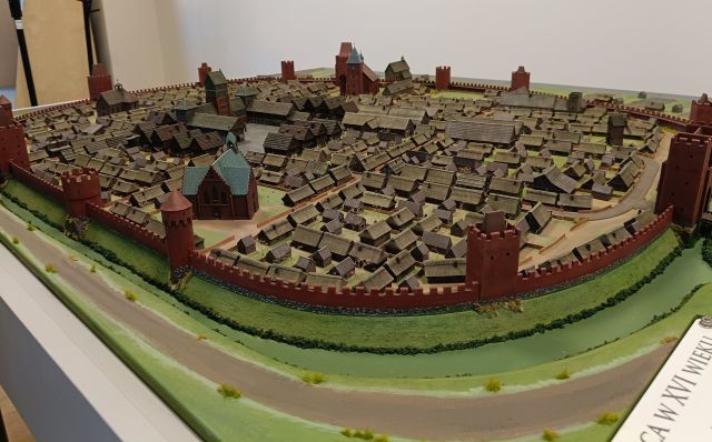 Na zdjęciu znajduje się makieta miasta Słupca, z domkami i kapliczkami. Zdjęcie zostało wykonane od boku.