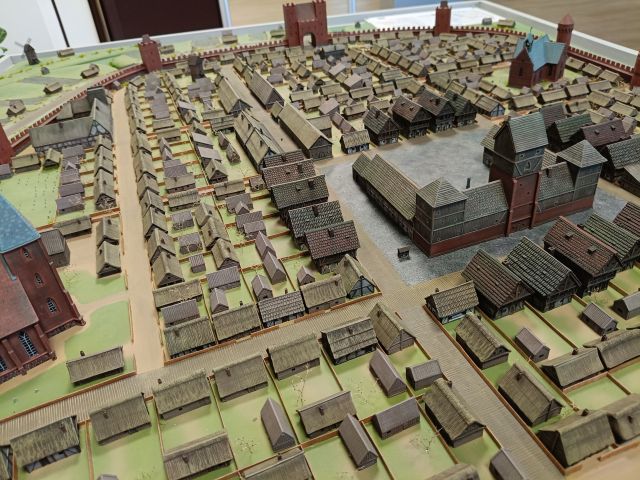 Na zdjęciu znajduje isę fragment makiety miasta przedstawiający domki, ratusz, gospody .