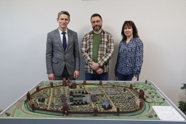 na zdjęciu burmistrz, twórca makiety i dyrektorka biblioteki stoją za makietą z XVI-wieczną Słupcą