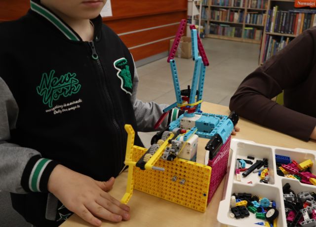 Na zdjęciu znajduje się helikopter zbudowany z LEGO i jest trzymany przez chłopca.