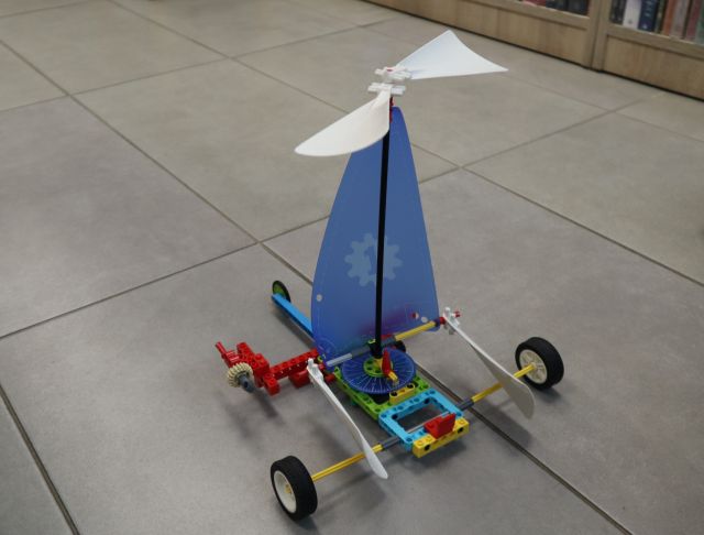 Na zdjęciu znajduje się zbudowana z klocków LEGO żaglówka, która stoi na podłodze.