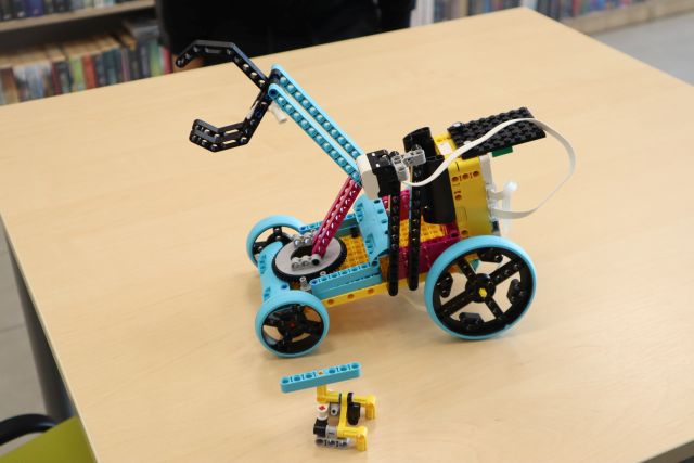 Na zdjęciu znajduje się stół, na którym stoi samochód z LEGO ze szczypcami.