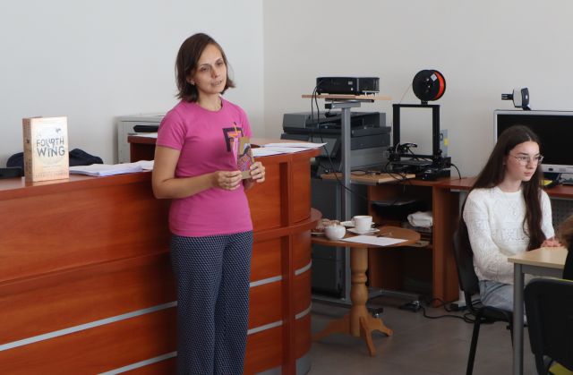 na zdjęciu stoi prowadząca warsztaty, w tle drukarka 3d na stole i rzutnik, za kobietą biurko