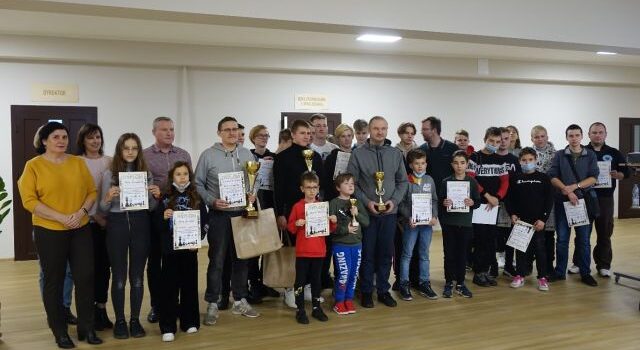 Na zdjęciu stoi 27 zawodników z dyplomami i opiekunowie oraz organizatorzy