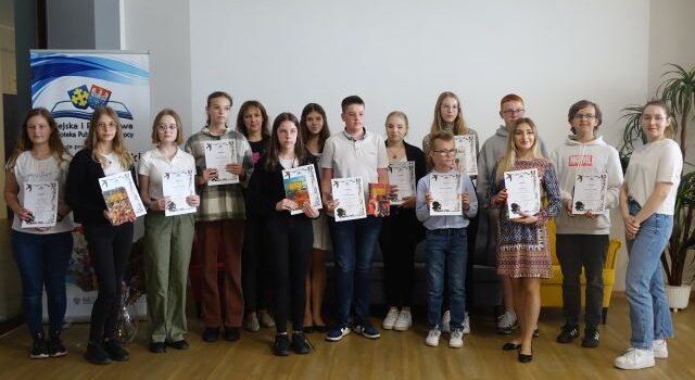 uczestnicy i laureaci konkursu pozują do zdjęcia z dyplomami