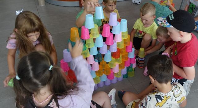 uczestnicy zajęć programują układając według kodu kolorowe kubeczki