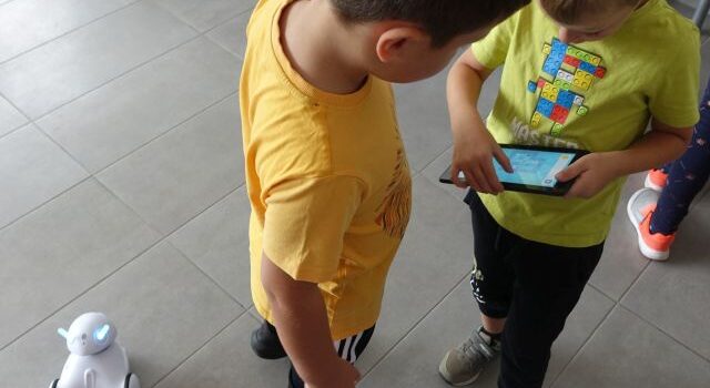 dzieci sterują robotami przy pomocy tabletów