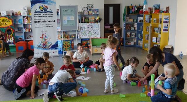 dzieci ukłądają wieże z kolorowych kubeczków