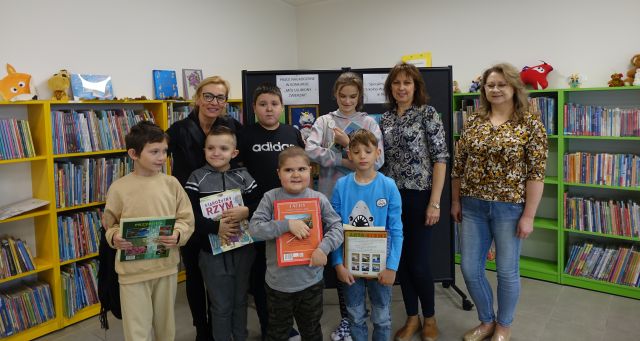 dzieci i 3 osoby dorosłe pozują do zdjęcia trzymając w rękach nagrody