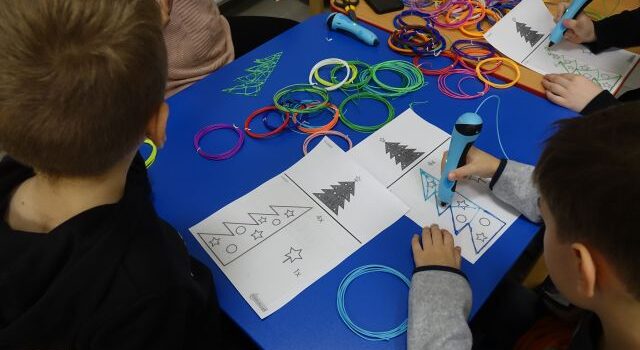 dzieci przy użyciu długopisów 3D tworzą choinki