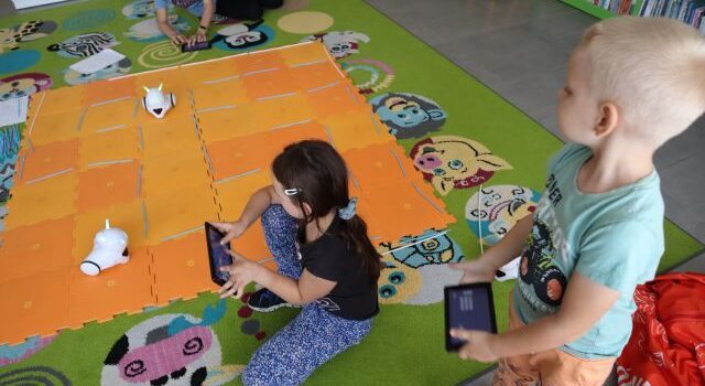 3 dzieci steruje przy użyciu tabletów robotami Photon