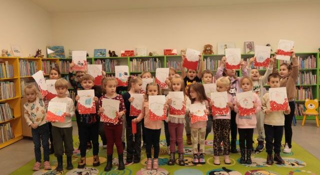 dzieci pozują do zdjęcia ze swoimi pracami plastycznymi
