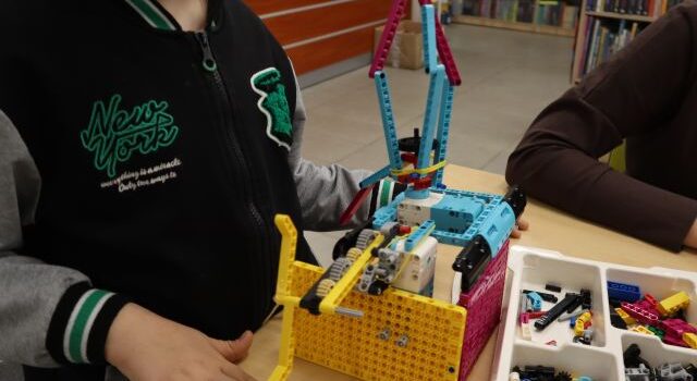 Na zdjęciu znajduje się helikopter zbudowany z LEGO i jest trzymany przez chłopca.